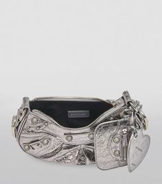 With its distinct brand of irreverence, Balenciaga, under the creative direction of Demna Gvasalia, never shies away from bold design and avant-garde details. The Le Cagole shoulder bag sees that in action, crafted from supple lambskin with a studded finish, the silhouette clearly takes influences from vintage design with its small, curved shape, silver hardware, removable mirror charm and extended zipper pulls. Heart Mirror, Bag Silver, Mini Charm, Classic Bags, Grey Diamond, Mini Shoulder Bag, Sneaker Heels, Trendy Accessories, Lanvin