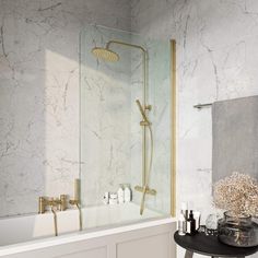 a bathroom with marble walls and flooring, including a bathtub that has a glass shower door