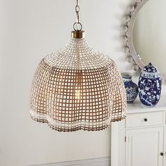 a light fixture hanging from a ceiling in a room with white walls and blue vases