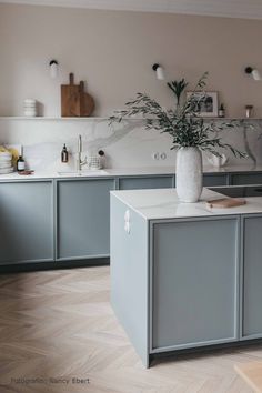 a kitchen with blue cabinets and white counter tops