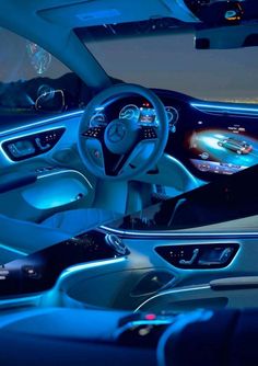 the interior of a car with blue lights and dashboard controls, including an illuminated steering wheel