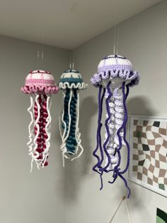 three crocheted jellyfish hanging from the ceiling