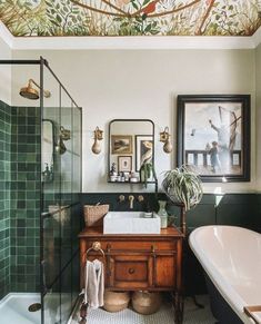 the bathroom is decorated with green tiles and wallpaper, along with a white bathtub