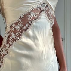 the back of a woman's wedding dress with white flowers on it and lace