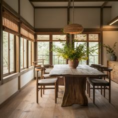 a dining room table with chairs and a potted plant on top of the table