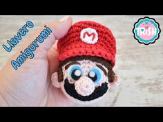 a small crocheted monkey wearing a red hat with big blue eyes and nose