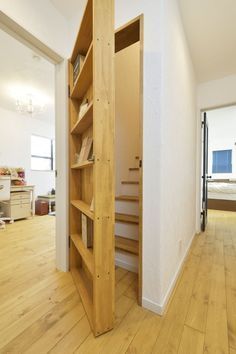 an open book shelf in the middle of a room with hardwood floors and white walls