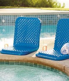 two blue chairs sitting next to a swimming pool