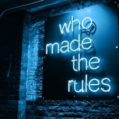 a neon sign that reads who made the rules