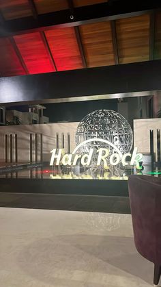 the hard rock sign is lit up in front of an empty room with chairs and tables