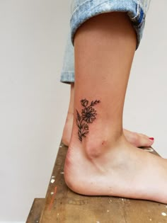 a woman's foot with a flower tattoo on her left side and right leg