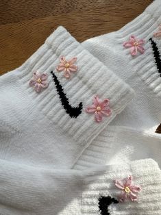 two pairs of white socks with pink flowers and black letters that spell i love you