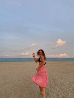 a woman standing on top of a sandy beach