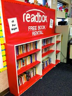 a red and white bookcase with free books on it in a room filled with children's toys