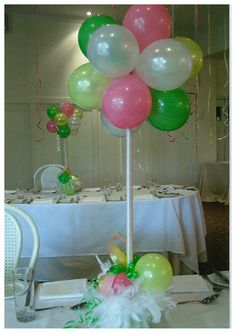 a table topped with lots of balloons and flowers