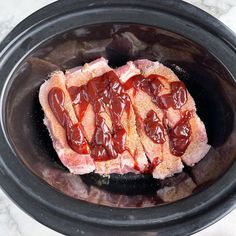 the meat in the slow cooker is covered with ketchup