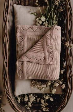 a basket with flowers and blankets in it