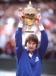 the tennis player is holding up his trophy