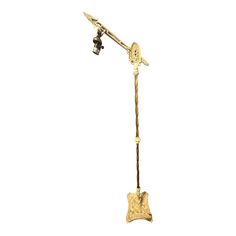 an antique brass floor lamp with a glass shade on the arm and base, in the shape of a star