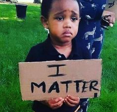 a little boy holding a sign that says i matter