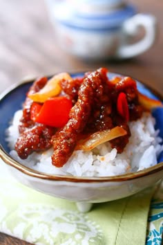 a bowl filled with rice and meat on top of a table