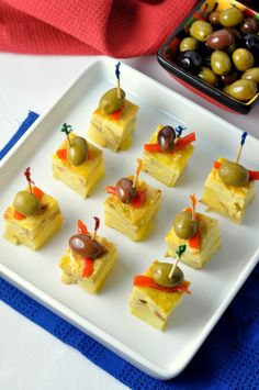 small appetizers with olives are on a plate