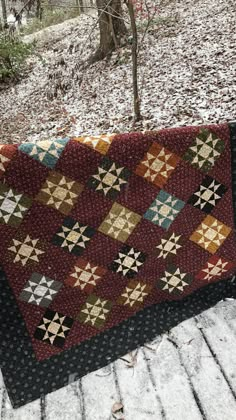 an old quilt on a bench in the woods