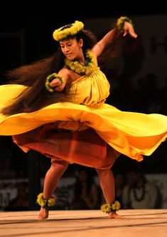 a woman in a yellow dress is dancing