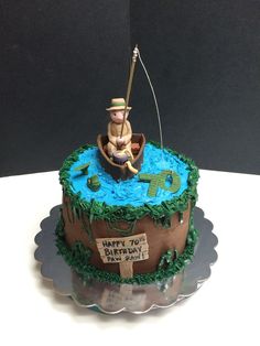 a birthday cake with a fishing theme on the top and an image of a man in a boat