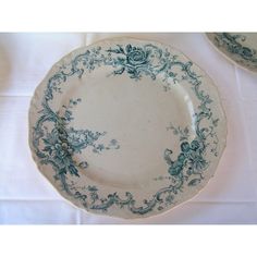 two blue and white plates sitting on top of a tablecloth covered table with napkins