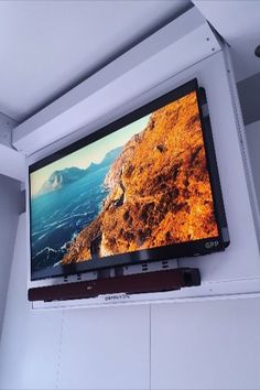 a flat screen tv mounted to the side of a wall in a room with white walls