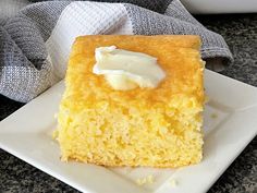 a piece of cake on a plate next to a napkin and bowl filled with whipped cream