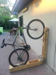 a bicycle is mounted to the side of a building with a wooden frame on it