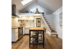 an open kitchen and dining area with stairs leading up to the second floor