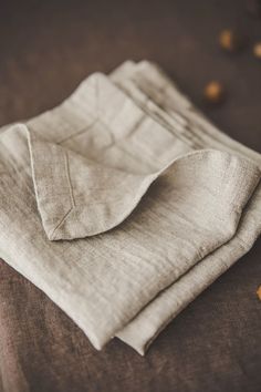 two linen napkins folded on top of each other with nuts scattered about the table