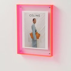 a pink neon frame with a photo of a woman holding a handbag on it