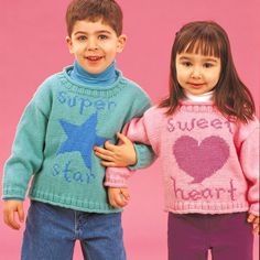 two children wearing sweaters with hearts and stars on them, standing next to each other