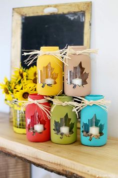 fall mason jar craft with candles and leaves on the top, sitting on a shelf