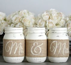 three mason jars with the names mr and mrs painted on them are sitting next to some flowers