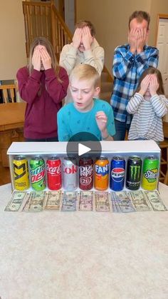 a group of people standing around a table covered in cans