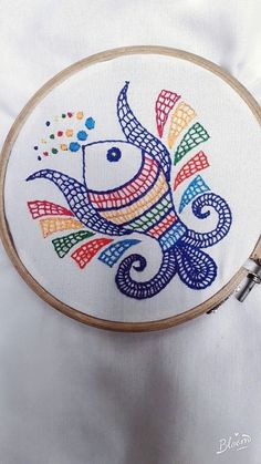 a colorful fish is shown on a white background and it appears to be in embroidery