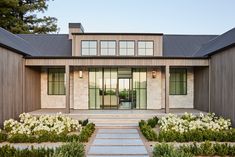 the front entrance of a modern home with stone steps leading up to it