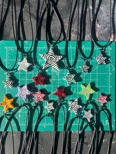 the scissors are laying on top of the cutting board with paper flowers in each one