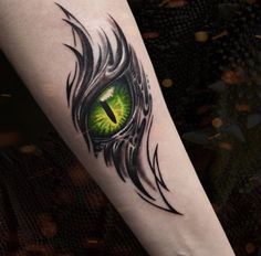 a green eye tattoo on the arm