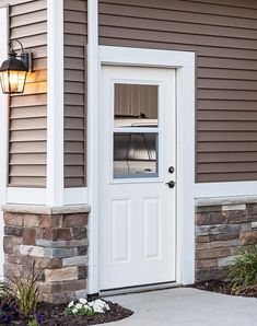 a white door with a glass window in front of a house