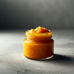 a jar filled with orange sauce sitting on top of a table