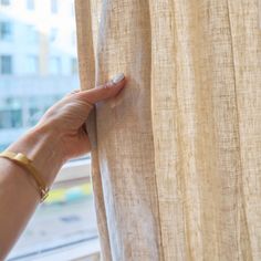 a woman's hand is holding on to the curtain