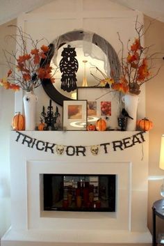 a white fireplace with halloween decorations on the mantle and trick or treat sign above it