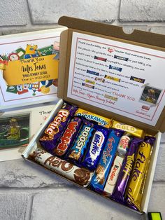 an open box filled with lots of different types of chocolates and candy bar wrappers