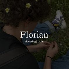 a woman sitting on the ground with her hands together and flowers in front of her